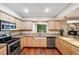 Well-lit kitchen features wood cabinets, granite counters, stainless steel appliances, and mural view at 505 S Larry Cir, Brandon, FL 33511