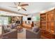 Inviting living room featuring stone fireplace, custom built-ins, modern furnishings, and stylish ceiling fan at 505 S Larry Cir, Brandon, FL 33511