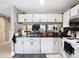 Bright kitchen featuring white cabinets, black countertops, and stainless steel sink at 5316 Ladywell Ct, Tampa, FL 33624