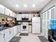 Well-equipped kitchen featuring white cabinets, modern appliances, and sleek black countertops for a contemporary feel at 5316 Ladywell Ct, Tampa, FL 33624
