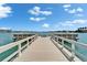 Long dock surrounded by water with a clear view of distant buildings at 5555 Gulf Blvd # 204, St Pete Beach, FL 33706