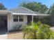 Inviting single-story home with a covered porch, showcasing lush landscaping and charming architectural details at 5725 2Nd N Ave, St Petersburg, FL 33710