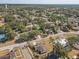 An aerial shot shows a community with tree-lined streets, featuring a glimpse of a nearby tennis court at 614 Sandalwood Dr, Plant City, FL 33563