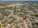 Aerial view of a charming residential area with lush greenery, featuring nearby schools, athletic fields, and a small pond at 614 Sandalwood Dr, Plant City, FL 33563
