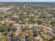Expansive aerial view of a neighborhood with mature trees and well-maintained homes, with a water tower in the distance at 614 Sandalwood Dr, Plant City, FL 33563