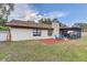 Backyard featuring a screened-in porch, chairs, mulched garden, and well-kept lawn at 614 Sandalwood Dr, Plant City, FL 33563