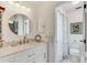 Bright bathroom with white vanity, marble countertop, round mirror and shower with patterned curtain at 614 Sandalwood Dr, Plant City, FL 33563