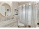Bathroom featuring marble countertop, framed mirror, shower with curtains, and toilet at 614 Sandalwood Dr, Plant City, FL 33563