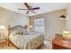 Cozy bedroom with ceiling fan, queen bed with tropical bedding and side tables with lamps at 614 Sandalwood Dr, Plant City, FL 33563