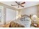 Bedroom with ceiling fan, queen bed and side tables with lamps next to sliding door closet at 614 Sandalwood Dr, Plant City, FL 33563