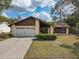 Charming single-Gathering home featuring a well-maintained front yard and a two-car garage at 614 Sandalwood Dr, Plant City, FL 33563