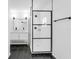 Modern bathroom with dark floors, vanity with framed mirror and a glass-enclosed shower at 621 85Th N Ave, St Petersburg, FL 33702