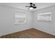 Well-lit bedroom with wood-look floors, white walls, and two windows with blinds at 621 85Th N Ave, St Petersburg, FL 33702