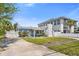 View of the light blue home with white picket fence, unique chimney, and adjacent property at 621 85Th N Ave, St Petersburg, FL 33702