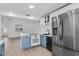 Well-lit kitchen featuring a stainless steel refrigerator, white cabinets, and blue accents at 621 85Th N Ave, St Petersburg, FL 33702