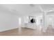Open-concept living space featuring light wood floors and a view of the modern, all-white kitchen at 621 85Th N Ave, St Petersburg, FL 33702
