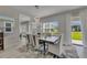 Elegant dining room featuring a modern chandelier, large mirror, and stylish chairs, complemented by natural light and backyard views at 6252 Hidden Branch Dr, Apollo Beach, FL 33572