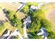 Aerial view of home featuring a lush backyard, screened in pool, mature trees, and circular driveway at 63 Forest Wood Ct, Spring Hill, FL 34609