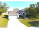 Aerial view of a charming home with a two-car garage, landscaped yard, and mature trees at 63 Forest Wood Ct, Spring Hill, FL 34609