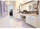 Bright bathroom featuring dual sinks, makeup vanity, large mirror, and neutral tile flooring at 63 Forest Wood Ct, Spring Hill, FL 34609
