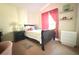 This bedroom with pink accents has a window, plush pillows, and two dressers for storage at 63 Forest Wood Ct, Spring Hill, FL 34609