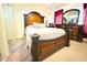 Bedroom featuring a large bed with dark wood headboard, bedside table, and dresser at 63 Forest Wood Ct, Spring Hill, FL 34609