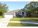 Charming single-story home featuring a well-manicured lawn, a two car garage, and mature trees at 63 Forest Wood Ct, Spring Hill, FL 34609