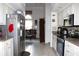 Open kitchen with stainless steel appliances and white cabinets, flowing into living area at 63 Forest Wood Ct, Spring Hill, FL 34609