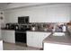 Kitchen showcasing white cabinetry, stainless steel appliances and tiled backsplash at 63 Forest Wood Ct, Spring Hill, FL 34609