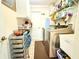 Functional laundry room with shelving, washer, dryer, and storage cart at 63 Forest Wood Ct, Spring Hill, FL 34609
