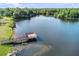 Aerial view of a wooden dock and walkway extending out into the waters of a serene lake at 6305 Bridgevista Dr, Lithia, FL 33547