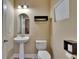 Neutral colored half bath with pedestal sink and storage shelves at 6918 Frog Pocket Pl, Tampa, FL 33616