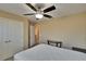 Neutral bedroom with a ceiling fan, closet doors, and a view into an adjacent room at 6918 Frog Pocket Pl, Tampa, FL 33616