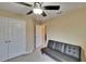 Spacious bedroom with a black futon and a view into an adjacent hallway at 6918 Frog Pocket Pl, Tampa, FL 33616