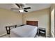 Neutral bedroom featuring a ceiling fan, a window with bright, natural light, and a dark-stained headboard at 6918 Frog Pocket Pl, Tampa, FL 33616