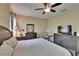 Bedroom with soft neutral color scheme, ceiling fan, and dark wooden furniture at 6918 Frog Pocket Pl, Tampa, FL 33616