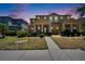 Inviting two-story townhome with manicured lawn and covered front porch at dusk at 6918 Frog Pocket Pl, Tampa, FL 33616