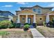 Inviting two-story townhome featuring a covered front porch with stately columns and professionally landscaped front yard at 6918 Frog Pocket Pl, Tampa, FL 33616