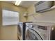 Close-up of laundry machines with shelving in a bright laundry room at 6918 Frog Pocket Pl, Tampa, FL 33616