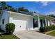 Bright, white home exterior with an attached garage, dark shutters and a welcoming covered porch at 7229 Northbridge Blvd, Tampa, FL 33615