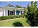 Home's exterior featuring a bright blue front door, green lawn, and charming white columns at 7229 Northbridge Blvd, Tampa, FL 33615