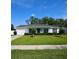 Inviting single-story white home with a well-maintained lawn, attached garage, and a charming blue front door at 7229 Northbridge Blvd, Tampa, FL 33615