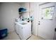 Functional laundry room with washer, dryer, shelving, and ample storage space at 7229 Northbridge Blvd, Tampa, FL 33615