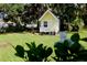 Charming yellow playhouse nestled in a lush green yard, perfect for outdoor fun and imaginative play at 7229 Northbridge Blvd, Tampa, FL 33615