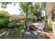 Lush backyard oasis featuring mature trees, patio area, and garden decor for relaxing outdoors at 7402 America Way, New Port Richey, FL 34654