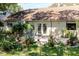 Charming backyard garden with lush greenery, flowering plants, and an inviting patio with elegant french doors at 7402 America Way, New Port Richey, FL 34654