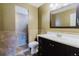 Bathroom with a shower and updated vanity with modern fixtures and earth-toned tile at 7402 America Way, New Port Richey, FL 34654