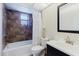 Well-lit bathroom featuring a shower-tub combo and a modern vanity at 7402 America Way, New Port Richey, FL 34654