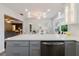 Contemporary kitchen with gray cabinets, stainless steel dishwasher and a white countertop overlooking the elegant living area at 7402 America Way, New Port Richey, FL 34654