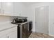 Convenient laundry room with side-by-side washer and dryer, ample counter space, and modern finishes at 7402 America Way, New Port Richey, FL 34654